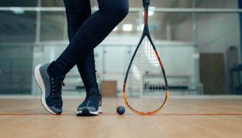 Female player legs, squash racket and ball. Girl on game training, active sport hobby on court, fitness workout for healthy lifestyle